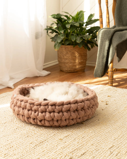 Cappuccino Solace Aura merino wool cat bed, hand-knitted round cat bed with soft wool interior, styled on a jute rug in a warm natural home setting