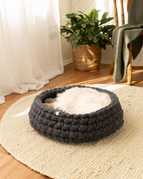 Handmade charcoal grey merino wool cat bed, round felted wool design styled in a neutral, natural home