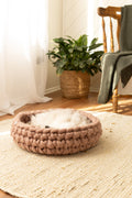 Cappuccino Solace Aura merino wool cat bed, hand-knitted round cat bed with soft wool interior, styled on a jute rug in a warm natural home setting