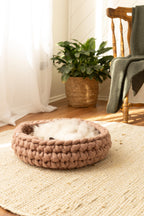 Cappuccino Solace Aura merino wool cat bed, hand-knitted round cat bed with soft wool interior, styled on a jute rug in a warm natural home setting