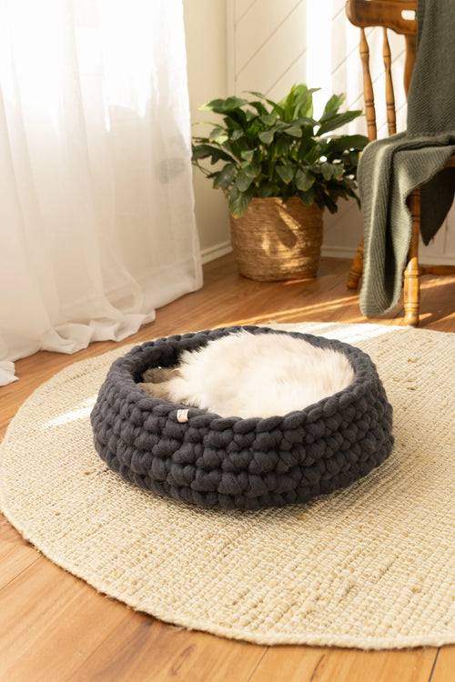 Handmade charcoal grey merino wool cat bed, round felted wool design styled in a neutral, natural home